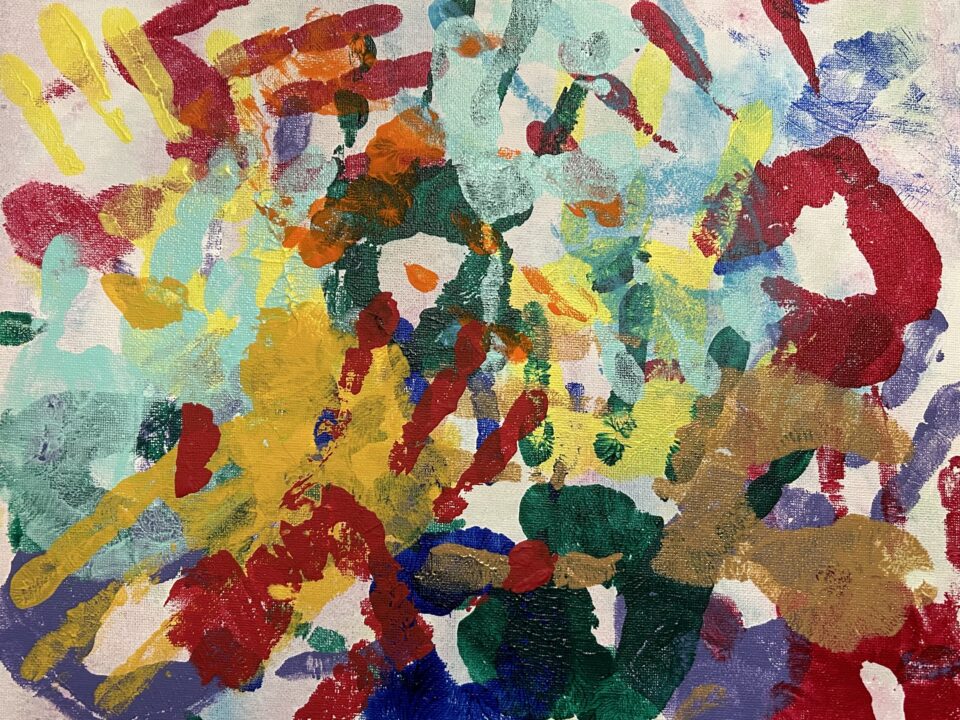 Colorful handprints cover a canvas